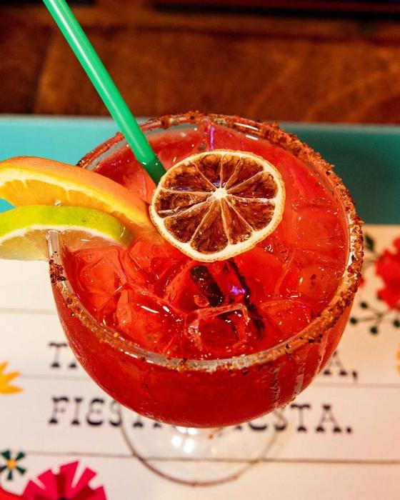 A red margarita with a dried orange wheel