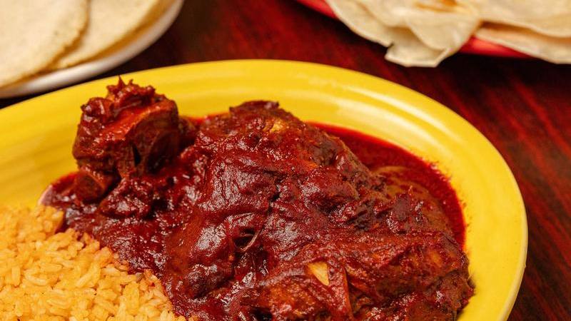 Costillas de puerco, pork ribs in red chile sauce, with rice and tortillas