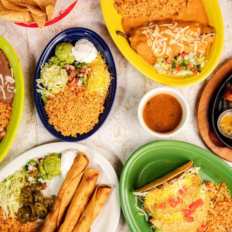A table spread of combination plates, flautas and sides