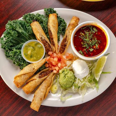 Birria flautas with consommé, guacamole and sour cream