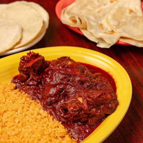 Costillas de puerco, pork ribs in red chile sauce, with rice and tortillas