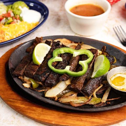 Beef fajitas with a green pepper ring and lime