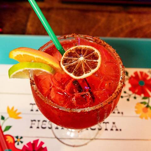 A red margarita with a dried orange wheel